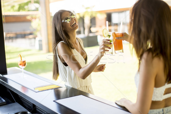 Young woman drinking coctail and having fun by the pool Stock photo © boggy