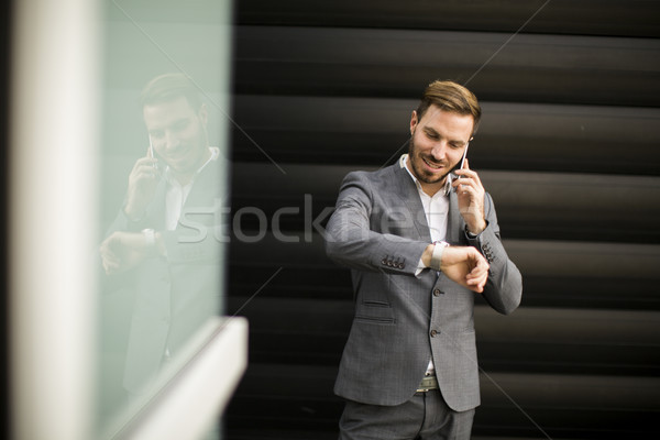 üzletember mobiltelefon néz óra pénzügyi negyed üzlet Stock fotó © boggy