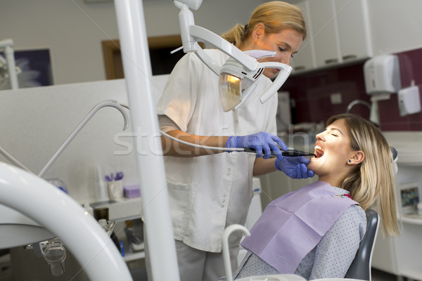 Doctor in uniform checking up female patient's teeth in dental c Stock photo © boggy