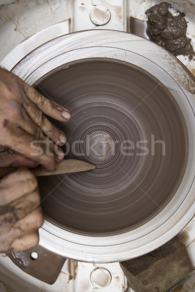 Artist makes clay pottery on a spin wheel Stock photo © boggy
