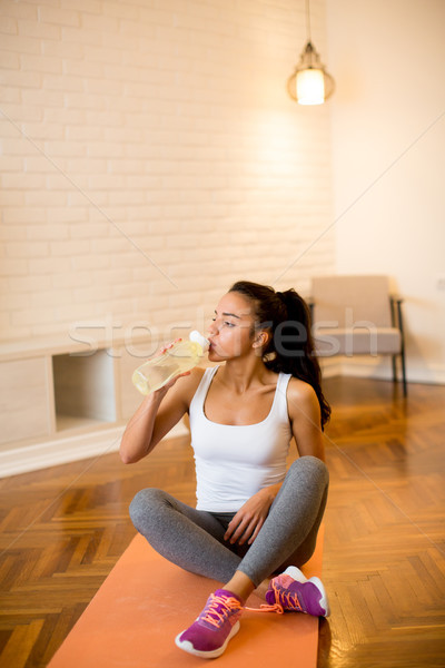 Mooie sport vrouw drinkwater vergadering yogamat Stockfoto © boggy