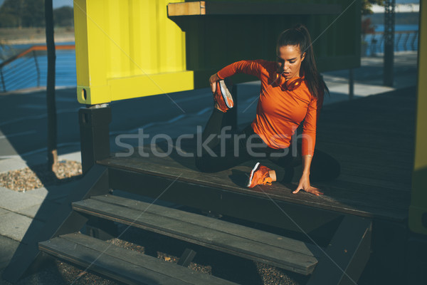 Young woman exercises on the promenade after running Stock photo © boggy
