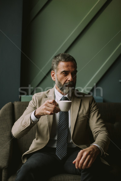 Gut aussehend Senior Geschäftsmann trinken Kaffee Lobby Stock foto © boggy