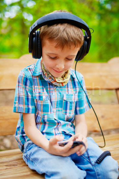 Young boy listening to music on headphones Stock photo © bogumil