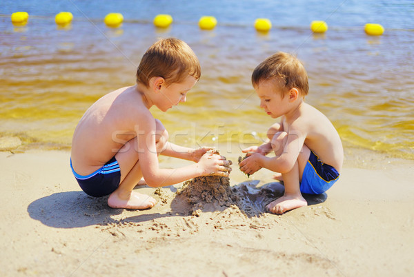 Two boys building sandcastle on the beach Stock photo © bogumil