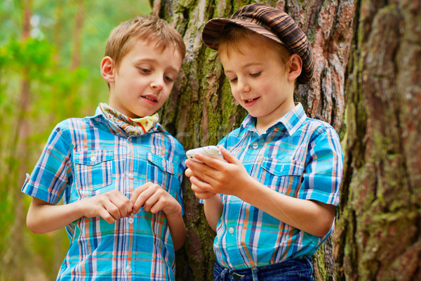 Young stylish boys browse the internet on mobile phone Stock photo © bogumil