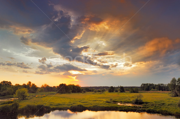 Stock photo: Beautiful sunrise and dramatic clouds on the sky. Flood waters of Narew river, Poland.