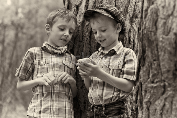 Young stylish boys browse the internet on mobile phone.  Stock photo © bogumil