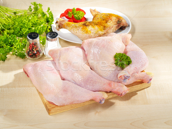 Fresh raw and roasted chicken legs arrangement on kitchen cuttin Stock photo © bogumil