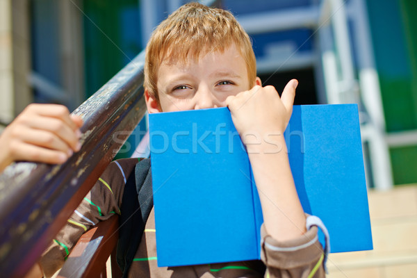 Young boy is hiding behind book. Stock photo © bogumil