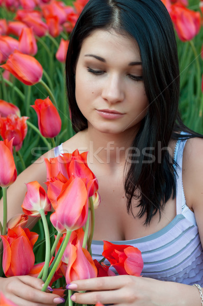 Woman looks at tulips. Stock photo © borysshevchuk