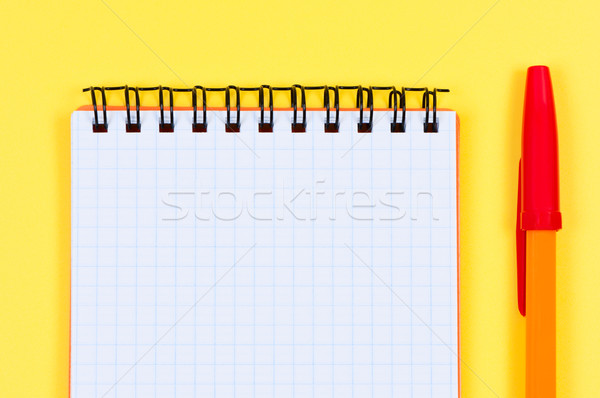 Notepad and ballpen on yellow background. Stock photo © borysshevchuk