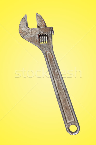 Old rusty wrench on yellow background. Stock photo © borysshevchuk