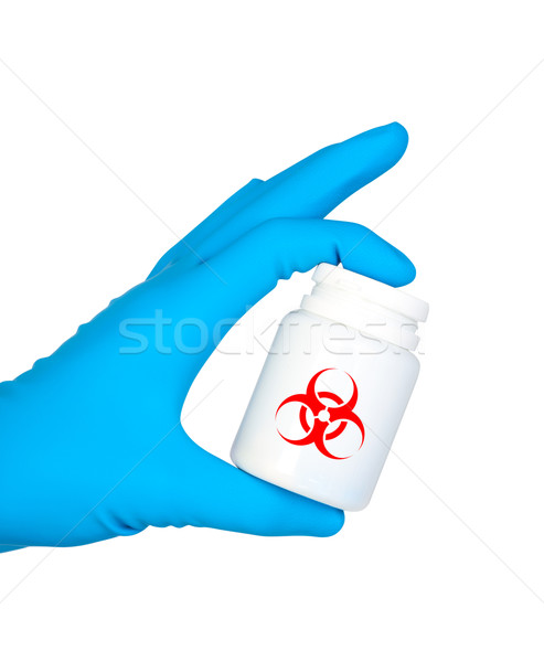 Hand holds jar of medicament with symbol biohazard. Stock photo © borysshevchuk