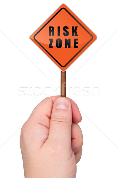 Warning sign risk zone holds in hand. Stock photo © borysshevchuk