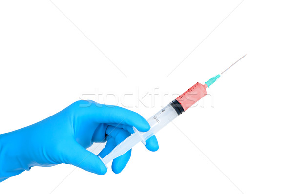 Hand in medical rubber glove holding medical syringe. Stock photo © borysshevchuk