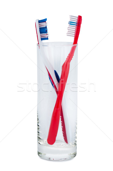 Two toothbrushes in a glass beaker. Stock photo © borysshevchuk