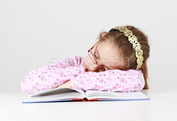 Tired schoolgirl sleeping on book Stock photo © brebca