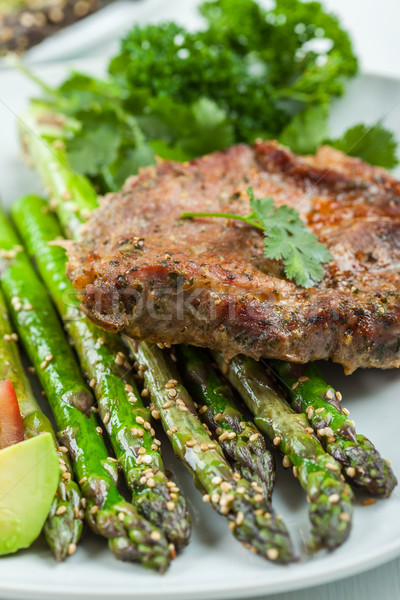 Glazed green asparagus with grilled pork chop Stock photo © brebca