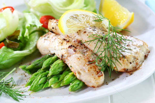 Fried fish on green asparagus with salad Stock photo © brebca