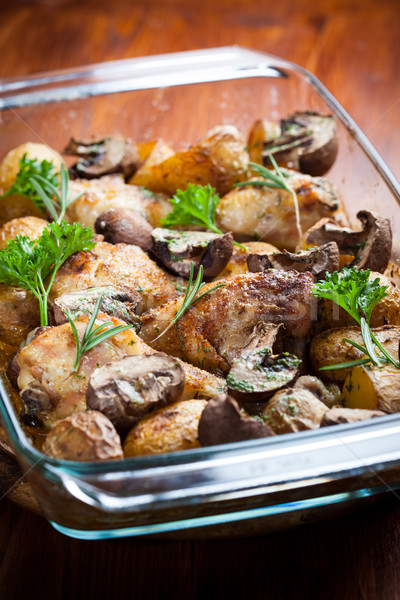 Stock photo: Baked chicken on potatoes and mushrooms