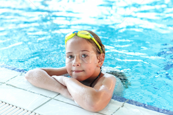 Happy girl with goggles in swimming pool Stock photo © brebca