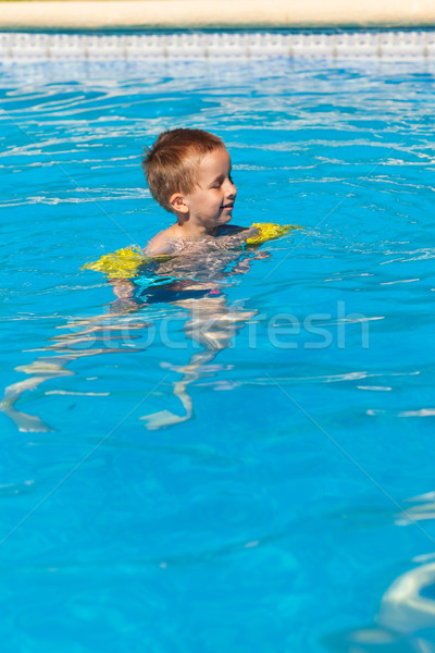 Happy boy swimming with floaties Stock photo © brebca