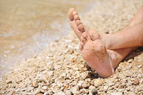 Relaxation on beach, detail of male feet Stock photo © brozova