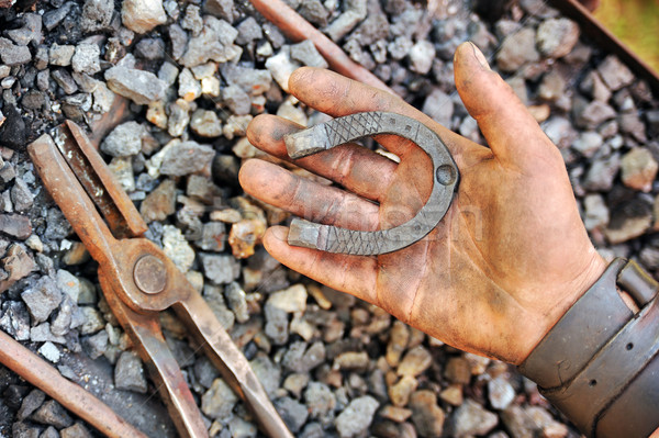 Detail of dirty hand holding horseshoe - blacksmith Stock photo © brozova