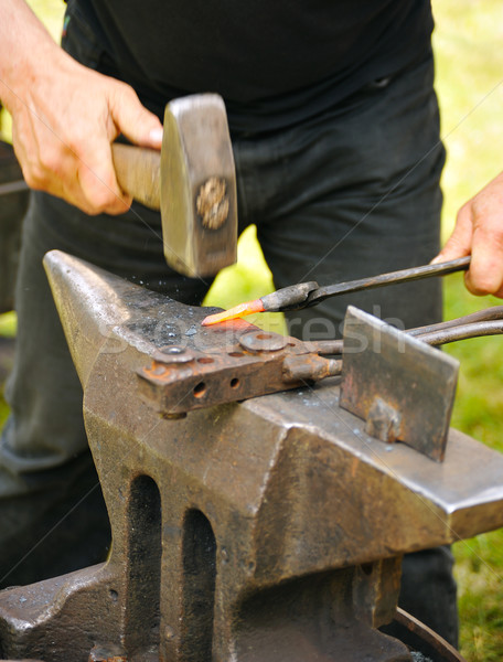 Blacksmith hammering hot iron on anvil Stock photo © brozova