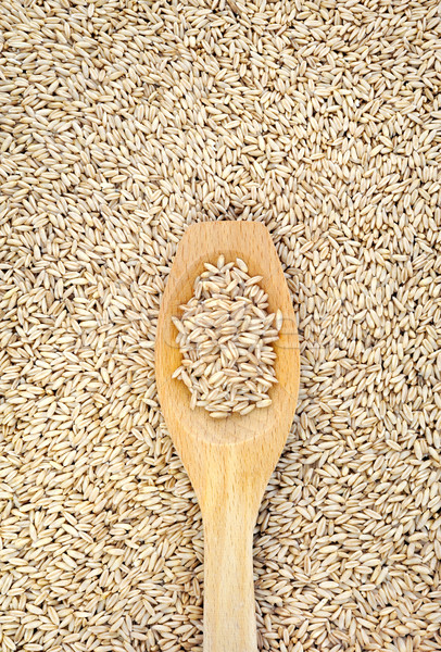 Wooden spoon and dried husked oats Stock photo © brozova