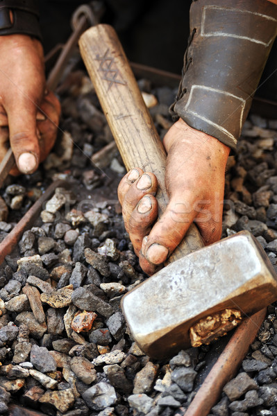 Detail of dirty hands holding hammer - blacksmith Stock photo © brozova