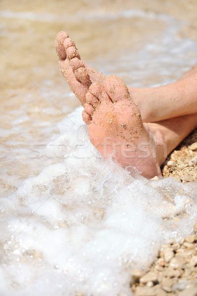 Relaxation on beach, detail of male feet Stock photo © brozova