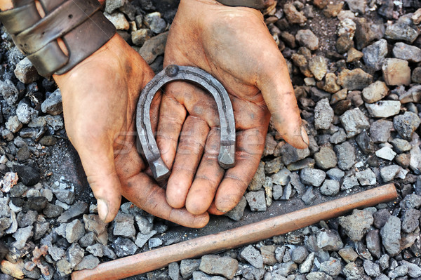 Detail of dirty hands holding horseshoe - blacksmith Stock photo © brozova