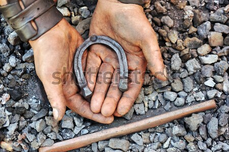 Detail of dirty hands holding horseshoe - blacksmith Stock photo © brozova