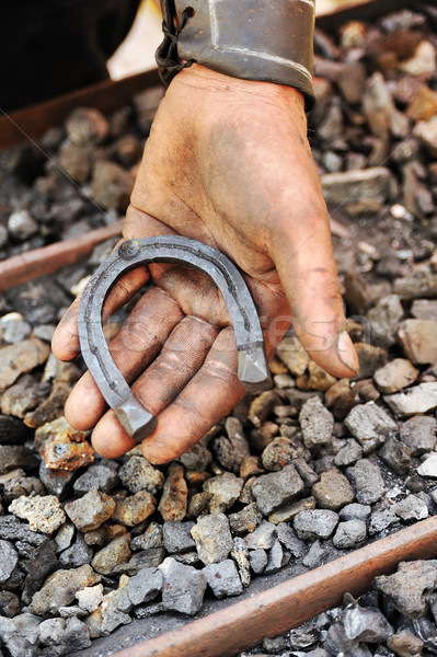 Detail of dirty hand holding horseshoe - blacksmith Stock photo © brozova