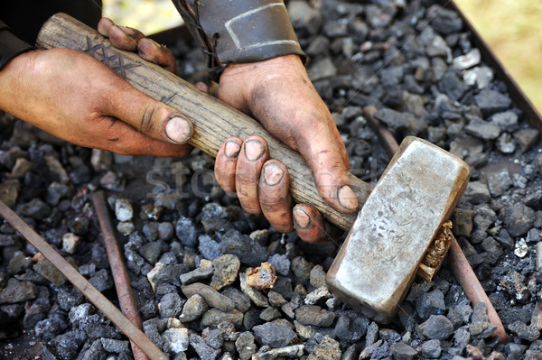 Detail of dirty hands holding hammer - blacksmith Stock photo © brozova