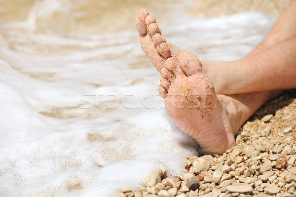 Relaxation on beach, detail of male feet Stock photo © brozova
