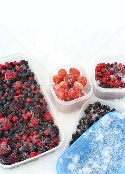 Plastic containers of frozen mixed berries in snow - red currant, cranberry, raspberry, blackberry,  Stock photo © brozova