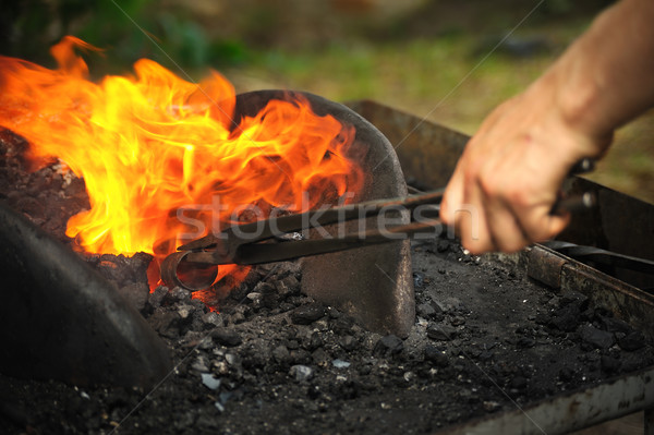 Blacksmith heating up iron - detail Stock photo © brozova