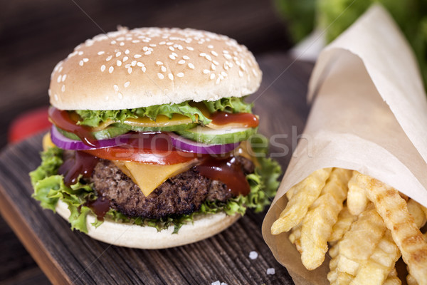 Beef burgers on a wooden board with chips and aromatic spices. Stock photo © BrunoWeltmann