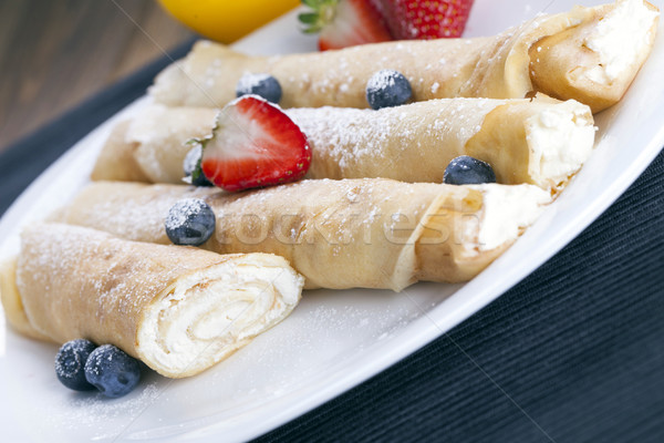 Delicious sweet rolled pancakes on a plate with fresh fruits Stock photo © BrunoWeltmann
