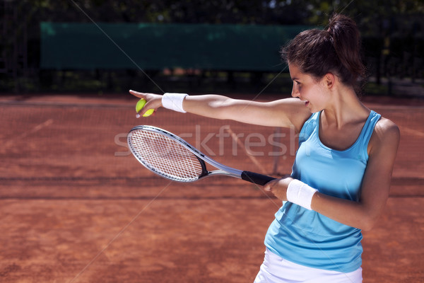 Stock photo: Young girl playing tennis on court