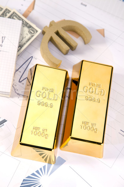 Stock photo: Gold bars on graphs and statistics