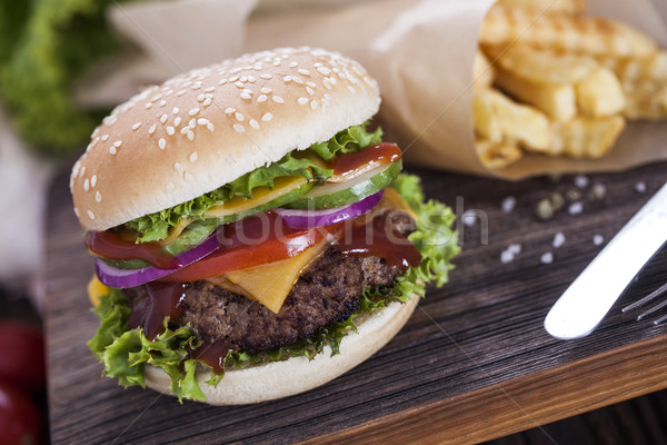 Beef burgers on a wooden board with chips and aromatic spices. Stock photo © BrunoWeltmann