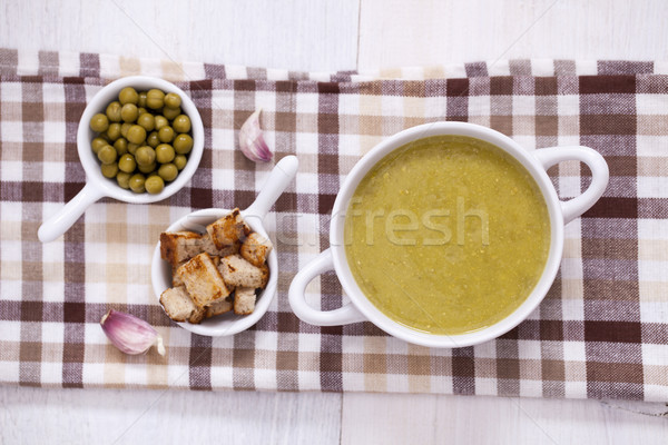 A delicious pea cream with aromatic spices on a wooden table. Stock photo © BrunoWeltmann