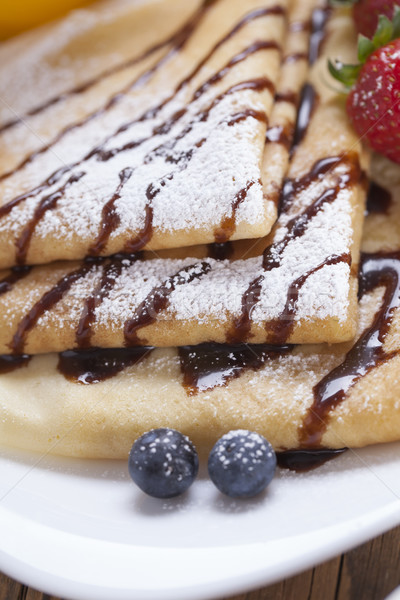 Delicious sweet French pancakes on a plate with fresh fruits Stock photo © BrunoWeltmann