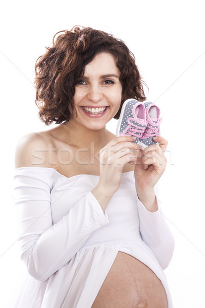 pregnant woman in a white dress holding a tiny baby shoes Stock photo © BrunoWeltmann