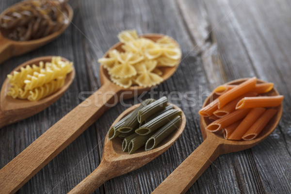 A set of raw pastas on spoons on a wooden table Stock photo © BrunoWeltmann