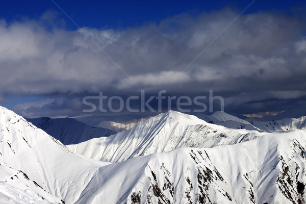 Snowy sunlit mountains and cloudy sky Stock photo © BSANI